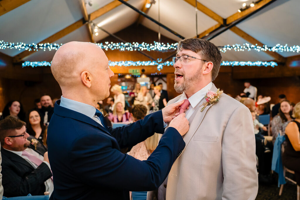 Steven having his buttonhole straightened at the front of the Horseshoe Barn before the ceremony