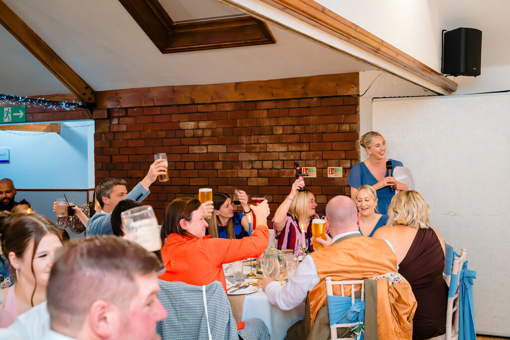 Wedding guests raising their glasses in a toast at the Stables Country Club