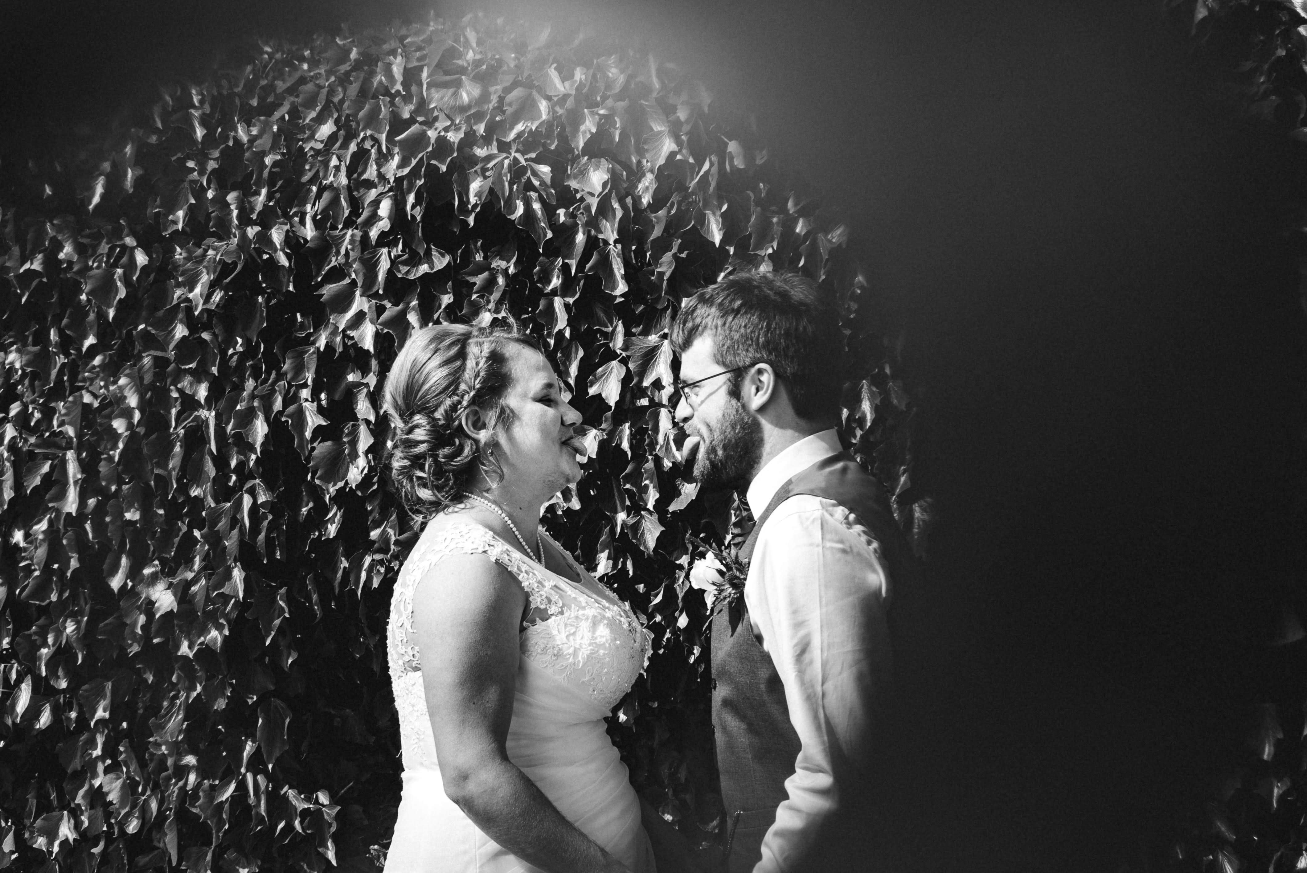 bride and groom sticking out tongues