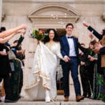 Bride and groom exiting wedding ceremony at Leeds Civic Hall joyfully.