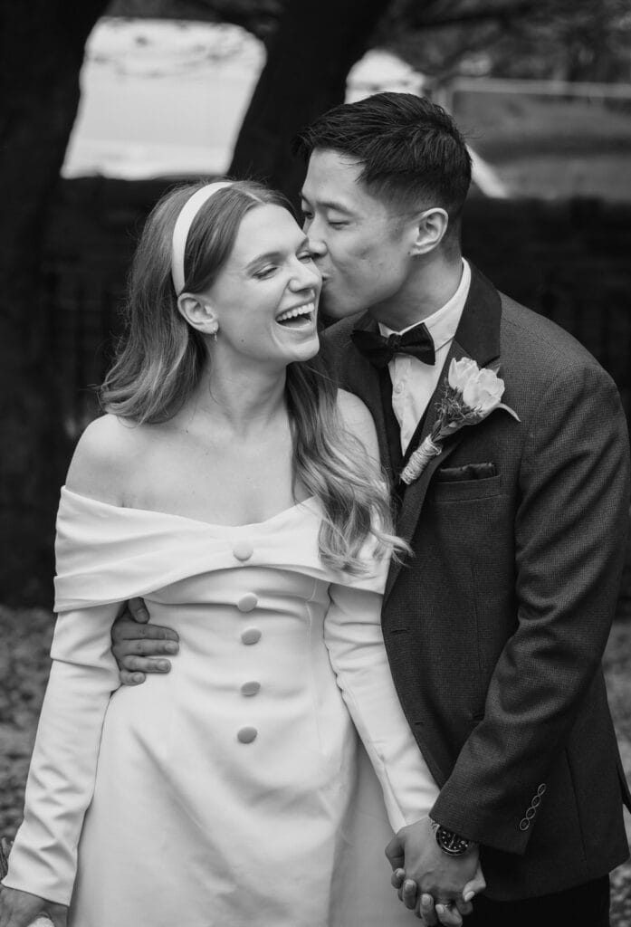 Couple laughing in wedding attire outside of Leeds Civic Hall