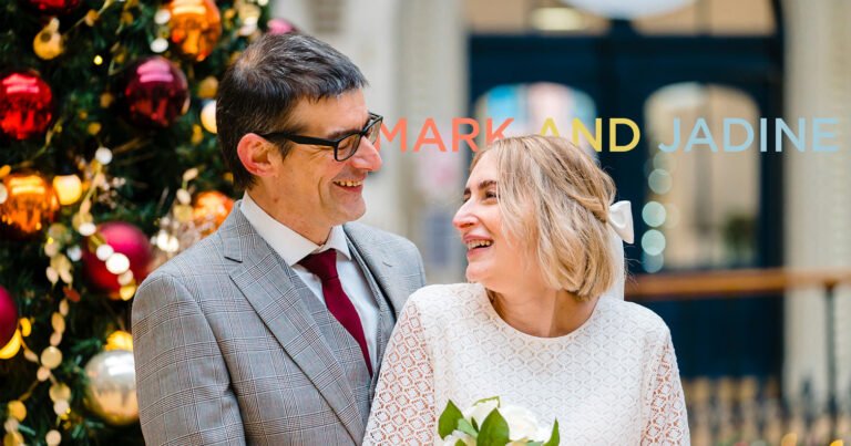 Couple smiling beside Christmas decorations