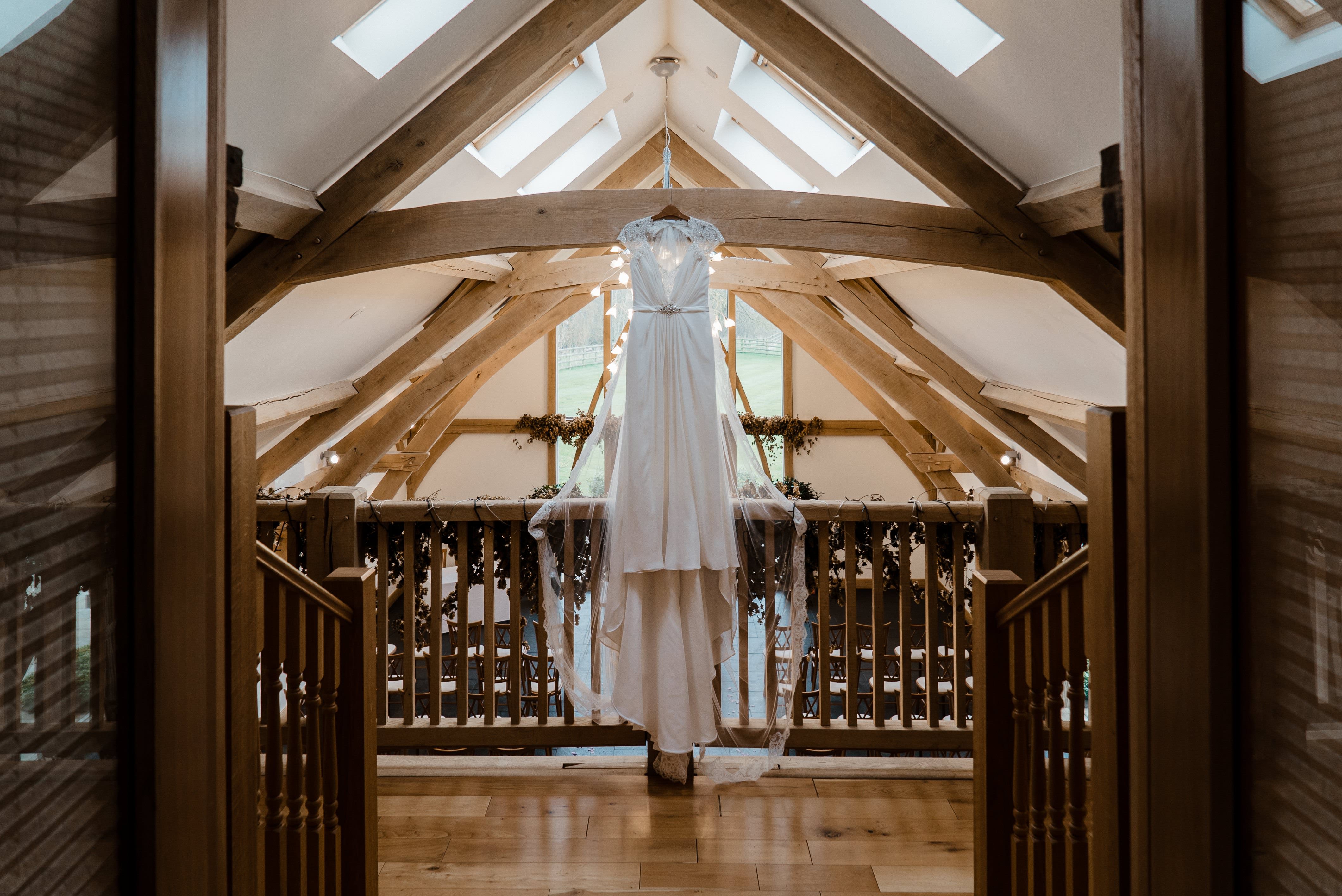 wedding dress hanging from barn