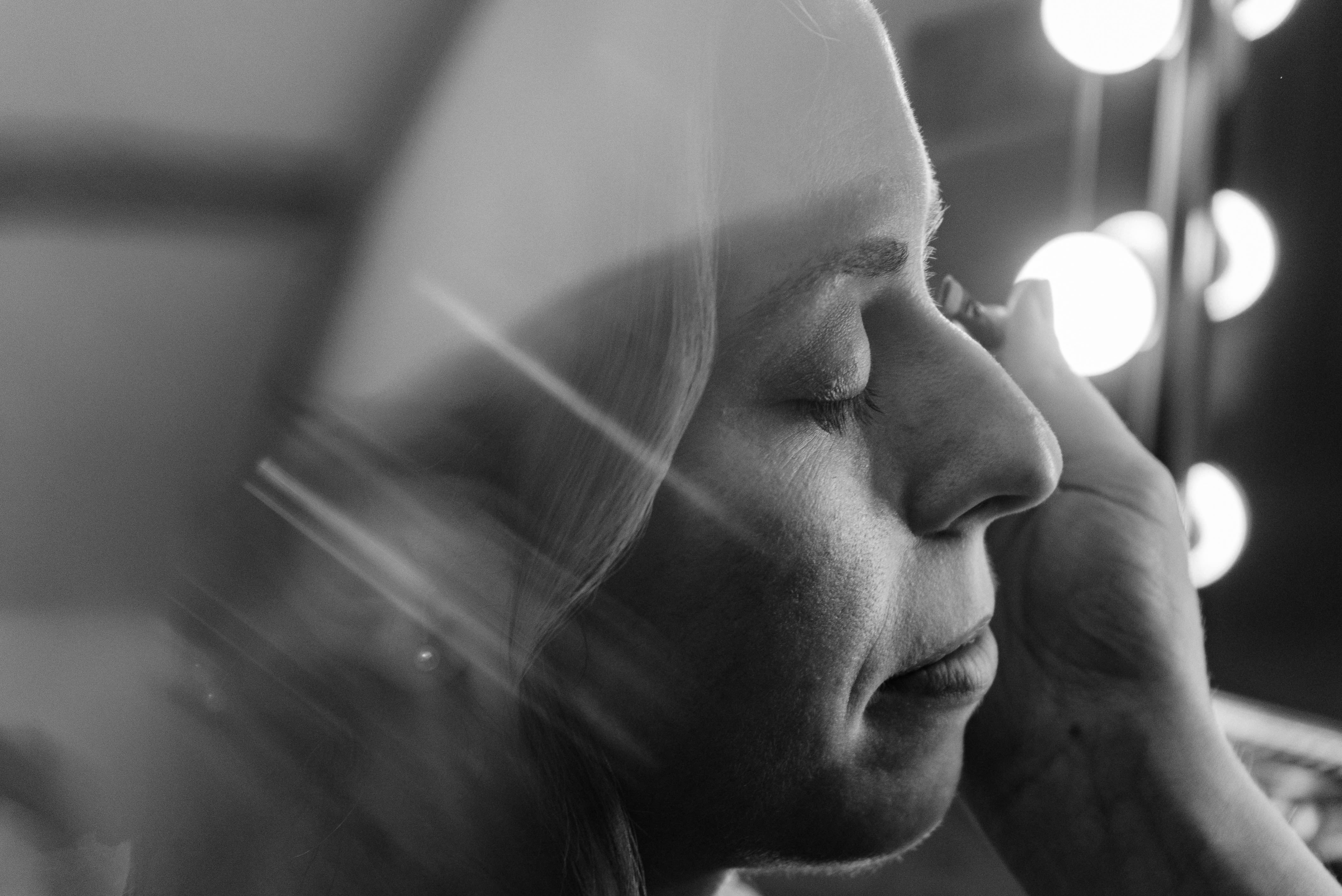 Bride getting makeup done in black and white
