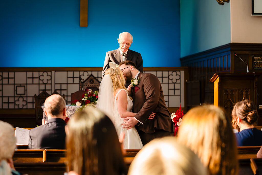 Black and white photo of Rebecca being helped out of the vintage wedding car at Dewsbury Baptist Church