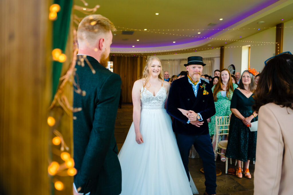 Bride walking down the aisle with father at The Out Barn.