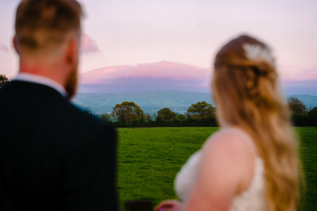 Couple admiring scenic countryside at sunset at The Out Barn.
