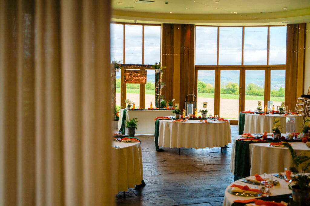 Elegant wedding venue with round tables and countryside view.