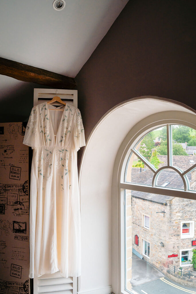 Wedding dress hanging in the window at the Coach House, Skipton