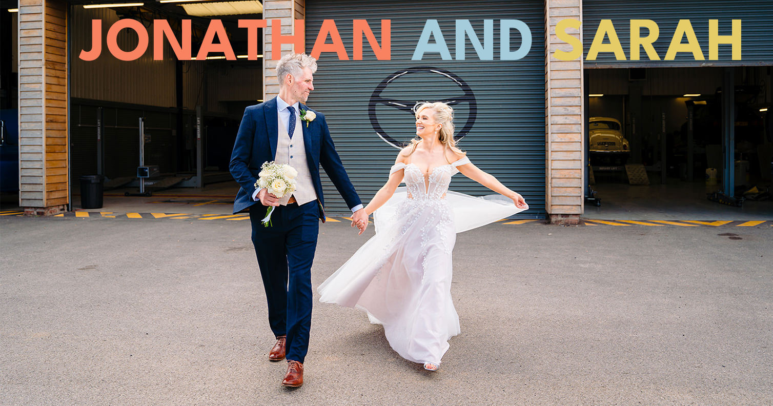 Wedding couple holding hands, industrial backdrop.